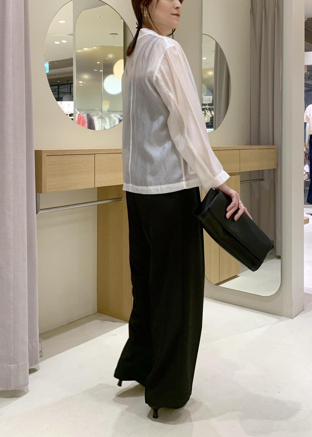 ブラック系のキャミソール、ブラック系のショルダーバッグ、ブラック系のパンプスを着用したレディースの春コーディネートの5枚目の写真