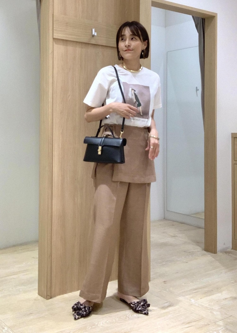 ホワイト系のTシャツ/カットソー、その他のサンダル、ブラウン系のスラックスを着用したレディースの夏コーディネートの2枚目の写真