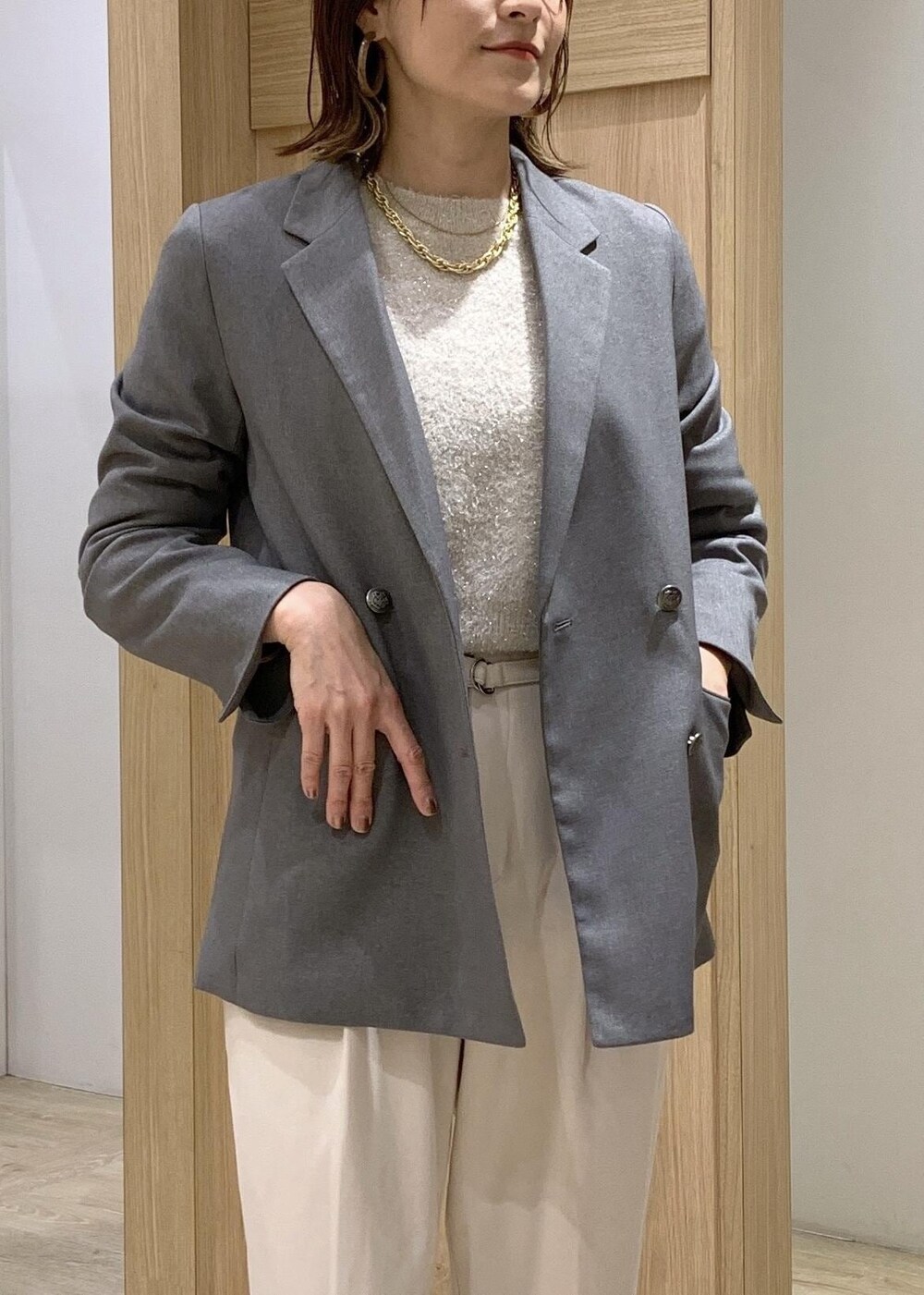 レッド系のトートバッグ、ホワイト系のブーツ、グレー系のテーラードジャケットを着用したレディースの冬コーディネートの6枚目の写真