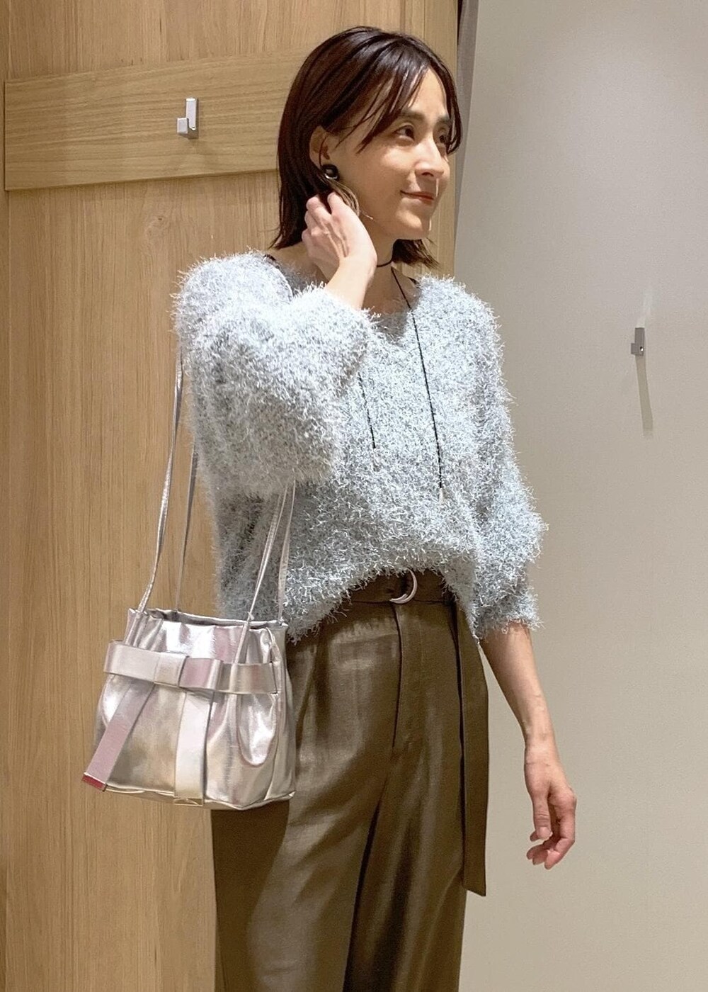 シルバー系のブーツ、グリーン系のニット/セーター、ブラウン系のその他パンツを着用したレディースの冬コーディネートの3枚目の写真