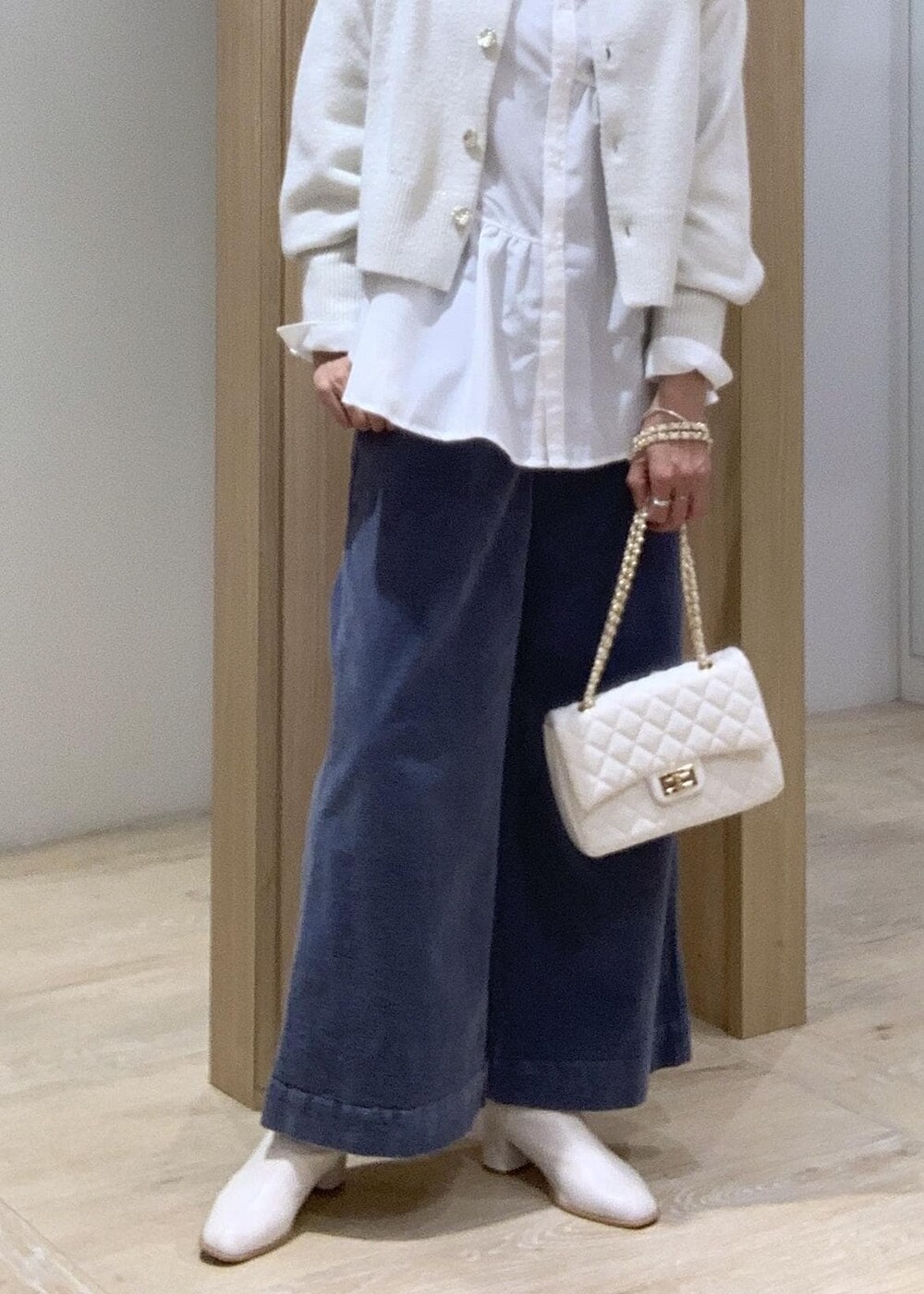ホワイト系のショルダーバッグ、ホワイト系のカーディガン/ボレロ、ホワイト系のブーツを着用したレディースの秋コーディネートの10枚目の写真
