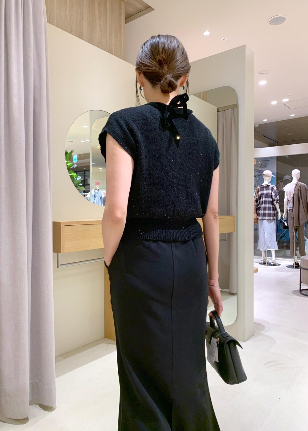 ブラック系のショルダーバッグ、ブラック系のカーディガン/ボレロ、ブラック系のキャミソールを着用したレディースの夏コーディネートの8枚目の写真