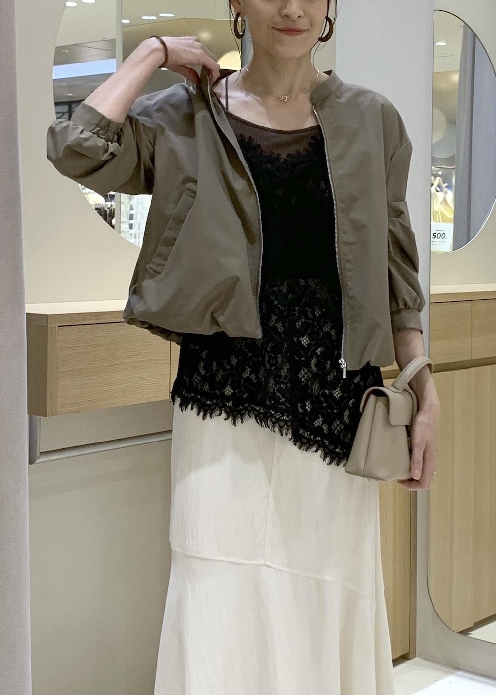 ベージュ系のパンプス、ホワイト系のスカート、ブラック系のキャミソールを着用したレディースの春コーディネートの7枚目の写真