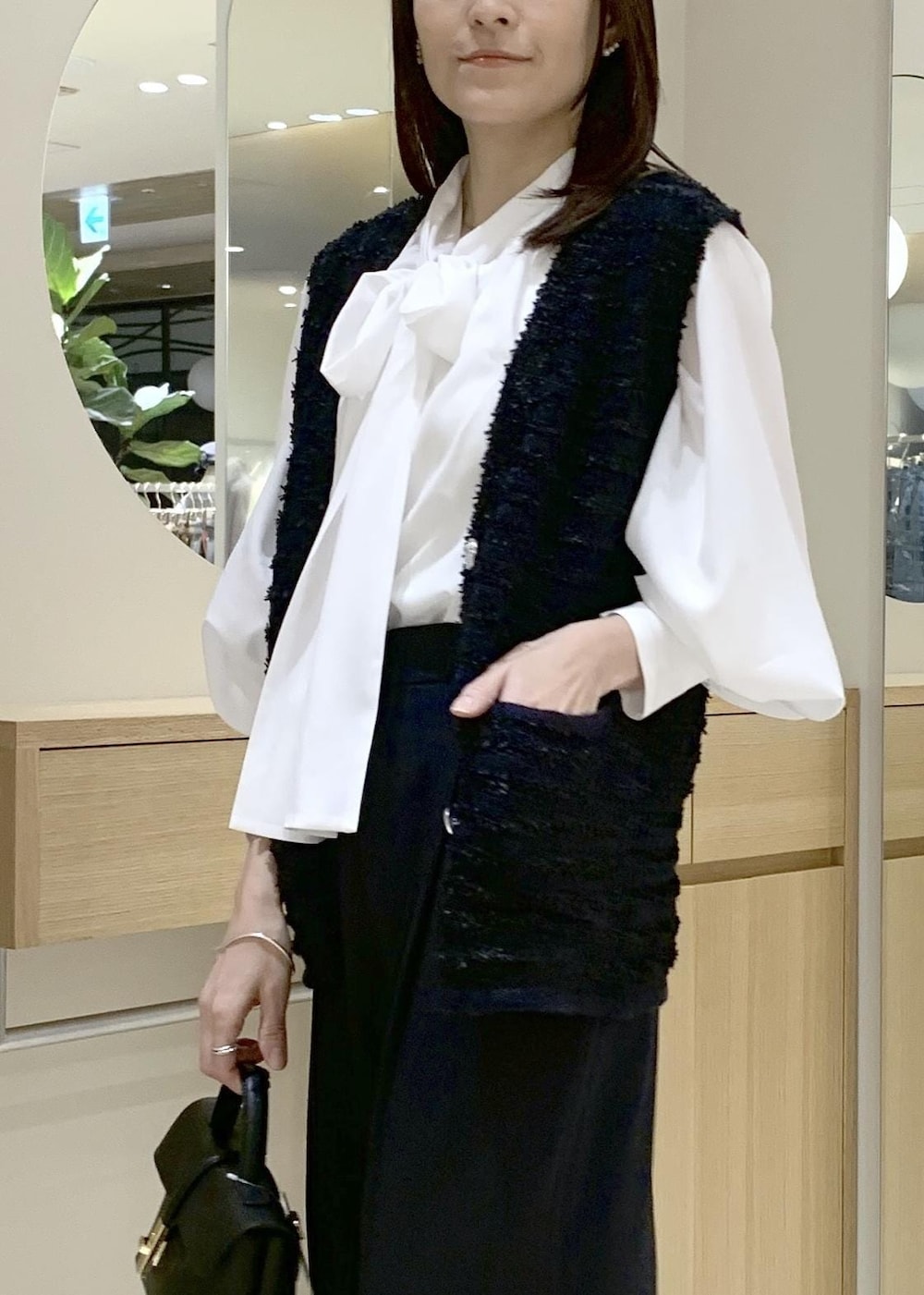 ブラック系のショルダーバッグ、ブルー系のその他パンツ、ホワイト系のシャツ/ブラウスを着用したレディースの冬コーディネートの5枚目の写真