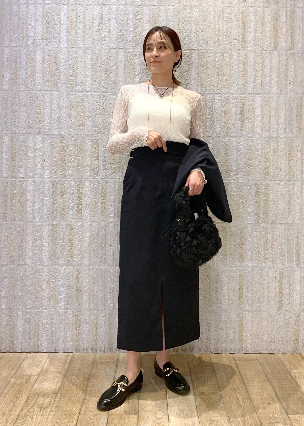 ブルー系のスカート、ホワイト系のTシャツ/カットソー、ブラック系のローファーを着用したレディースの冬コーディネートの7枚目の写真