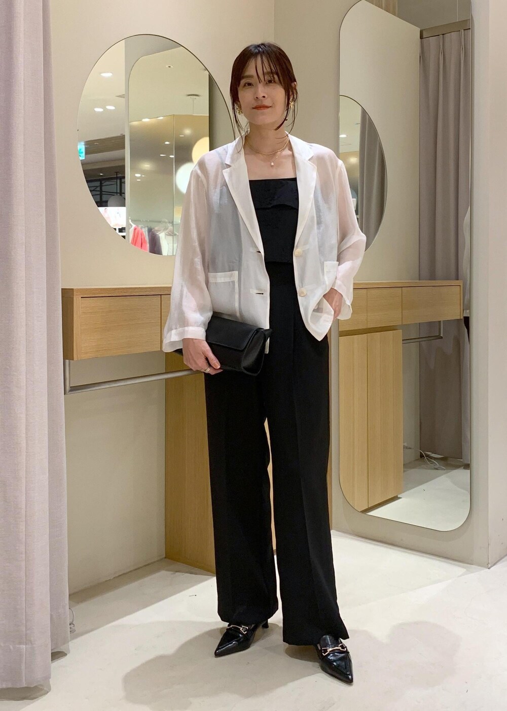 ブラック系のキャミソール、ブラック系のショルダーバッグ、ブラック系のパンプスを着用したレディースの春コーディネートの2枚目の写真