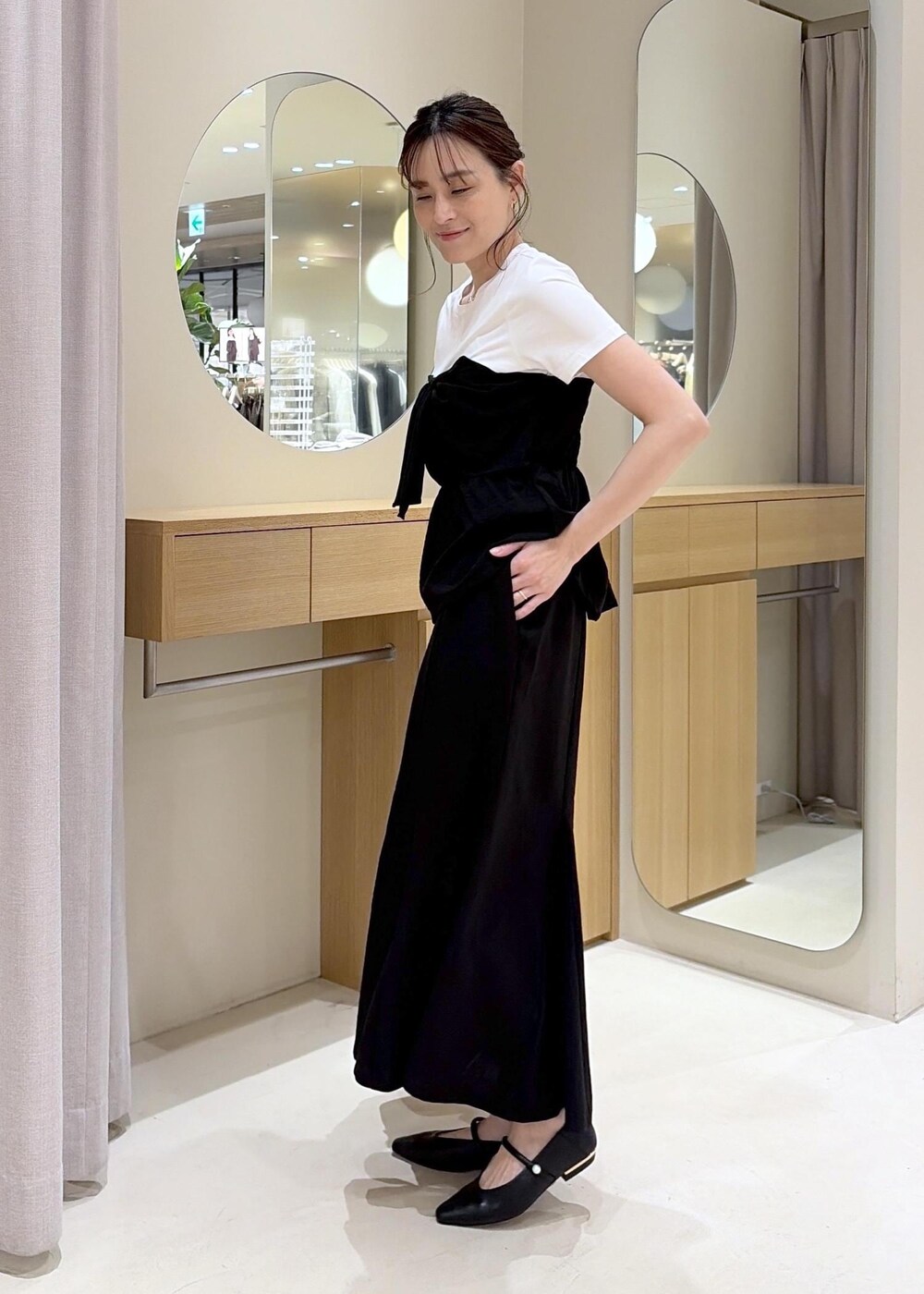 ベージュ系のトートバッグ、ブラック系のパンプス、ブラック系のTシャツ/カットソーを着用したレディースの春コーディネートの6枚目の写真