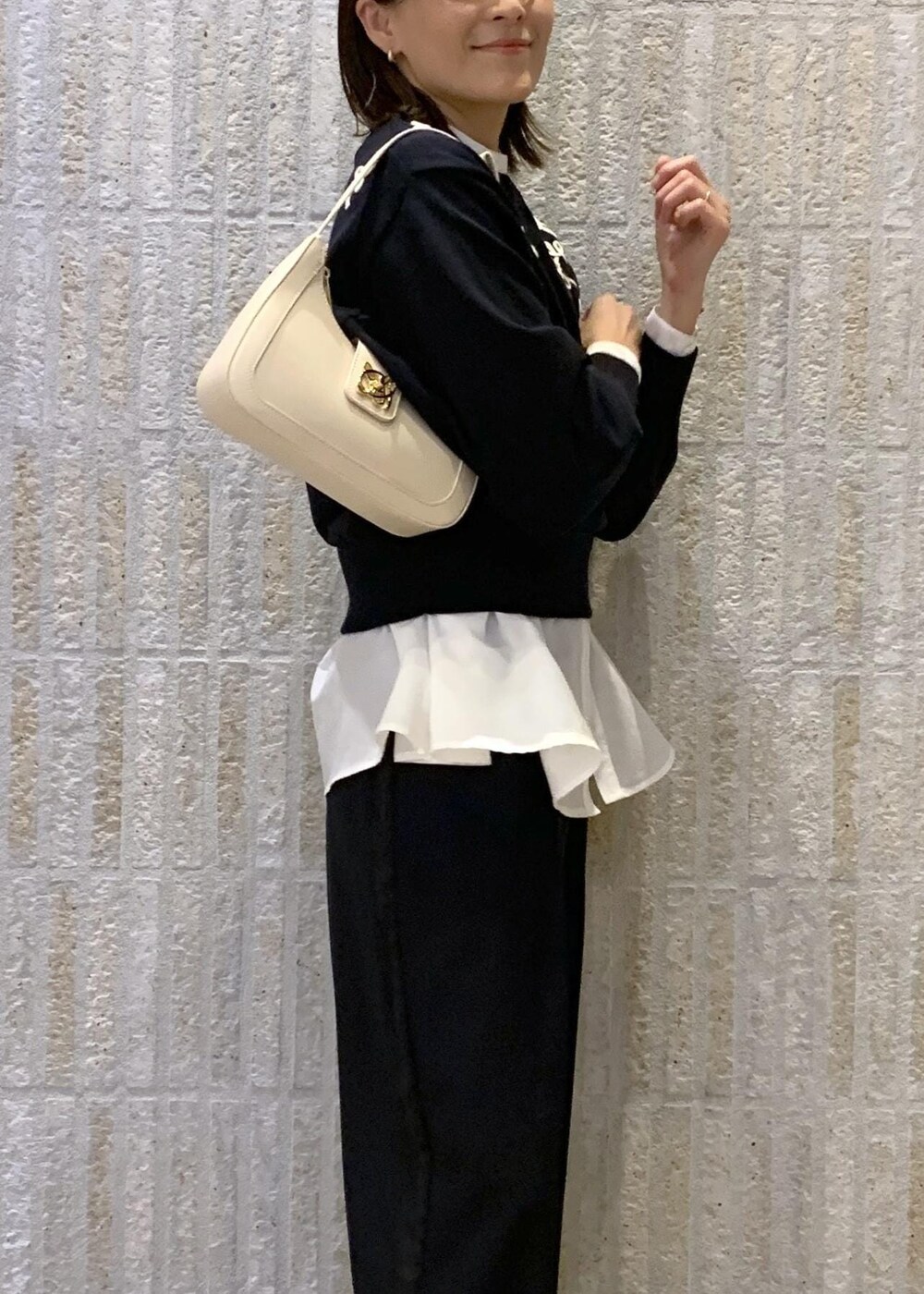 シルバー系のパンプス、ホワイト系のシャツ/ブラウス、ホワイト系のハンドバッグを着用したレディースの冬コーディネートの4枚目の写真