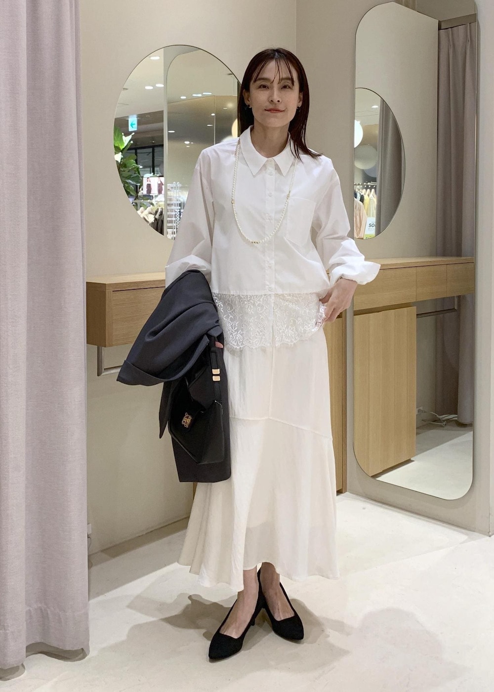 ブラック系のショルダーバッグ、ホワイト系のシャツ/ブラウス、ホワイト系のスカートを着用したレディースの春コーディネートの6枚目の写真