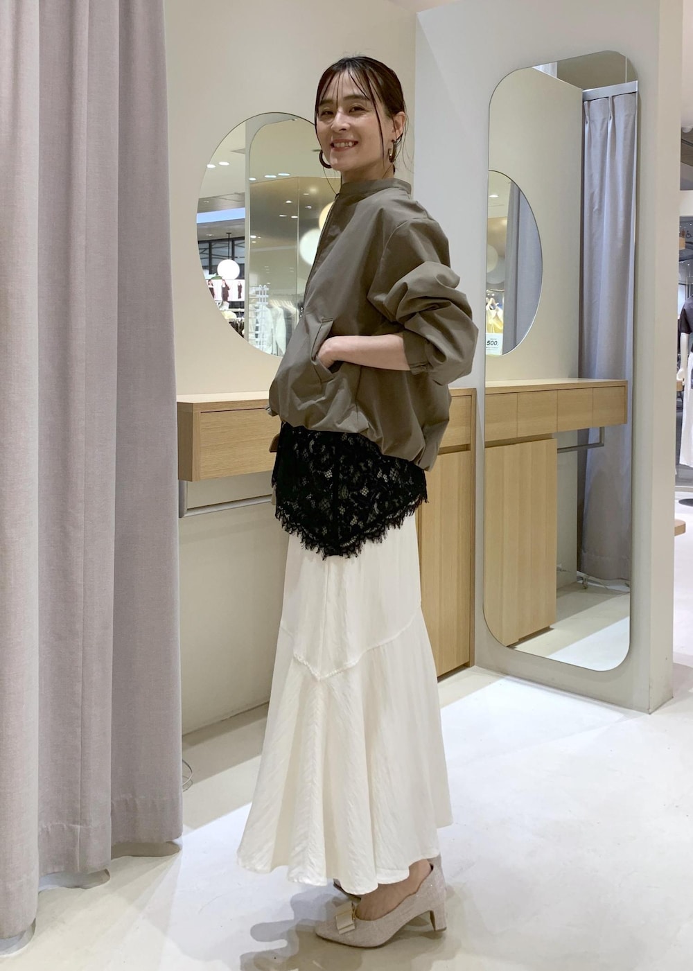 ベージュ系のパンプス、ホワイト系のスカート、ブラック系のキャミソールを着用したレディースの春コーディネートの4枚目の写真