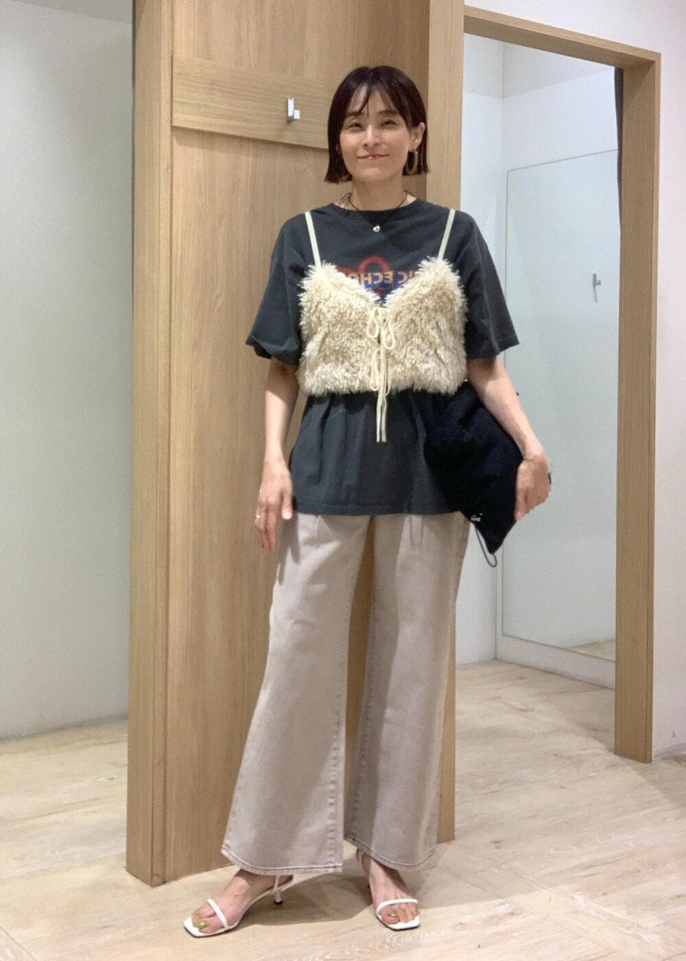 ホワイト系のサンダル、ブラック系のショルダーバッグ、ホワイト系のキャミソールを着用したレディースの夏コーディネートの2枚目の写真