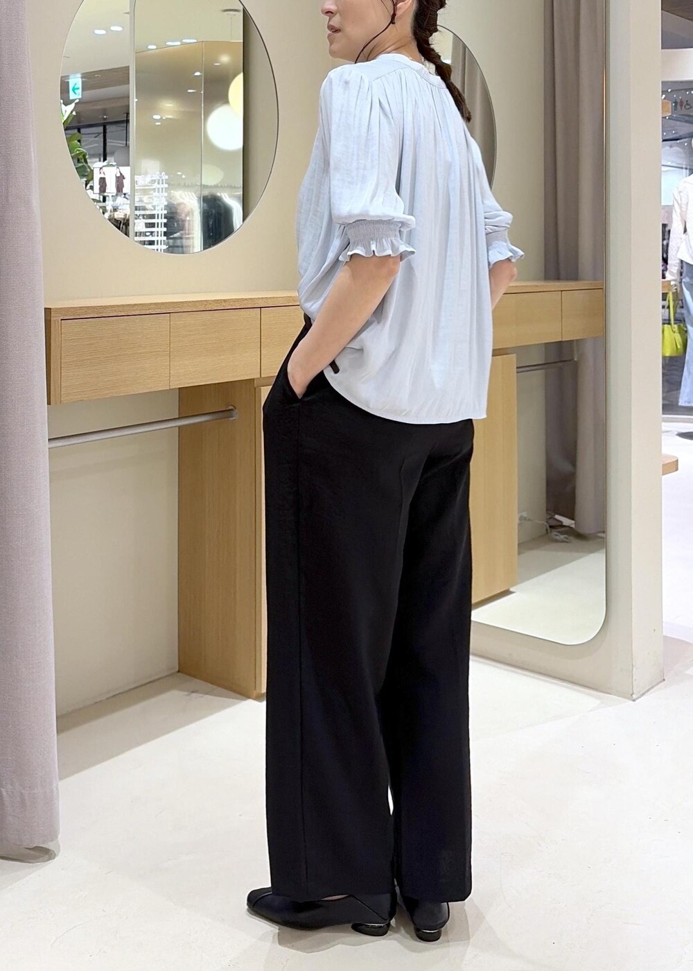 ブラック系のパンプス、ブルー系のシャツ/ブラウス、ブラック系のその他パンツを着用したレディースの春コーディネートの6枚目の写真