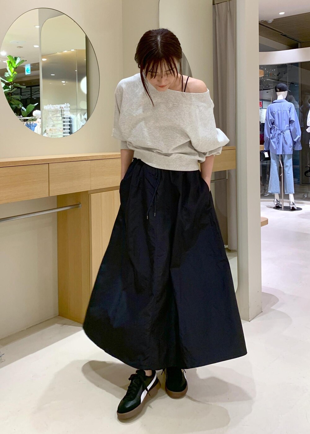 ブラック系のキャミソール、ブルー系のスカート、ホワイト系のスウェットを着用したレディースの春コーディネートの6枚目の写真