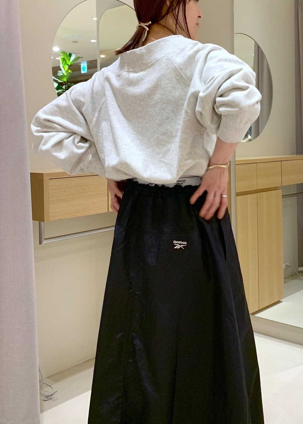 ブラック系のキャミソール、ブルー系のスカート、ホワイト系のスウェットを着用したレディースの春コーディネートの10枚目の写真