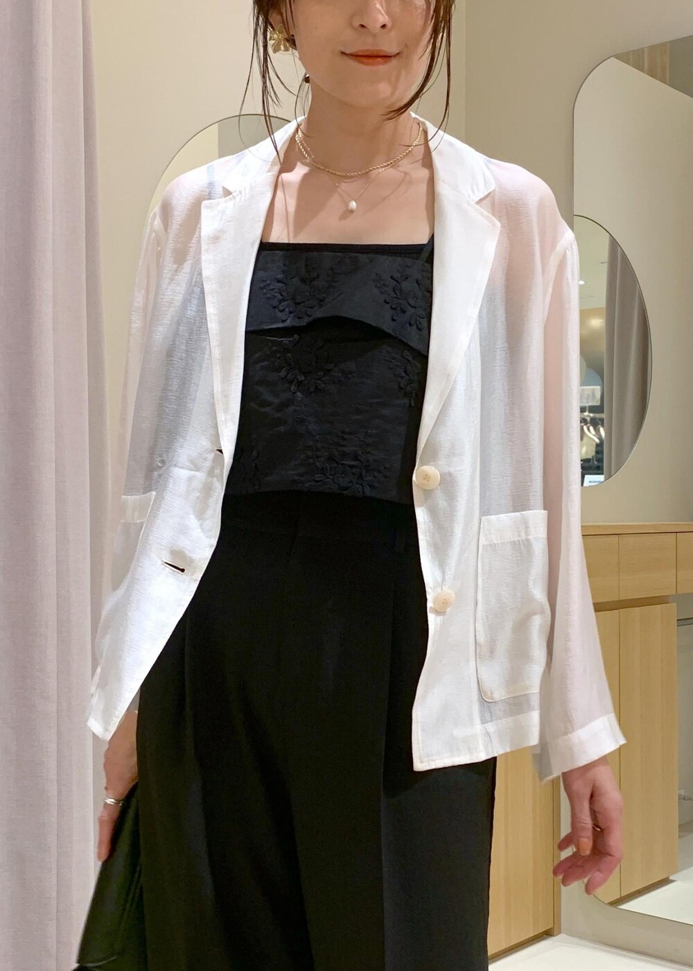 ブラック系のキャミソール、ブラック系のショルダーバッグ、ブラック系のパンプスを着用したレディースの春コーディネートの7枚目の写真