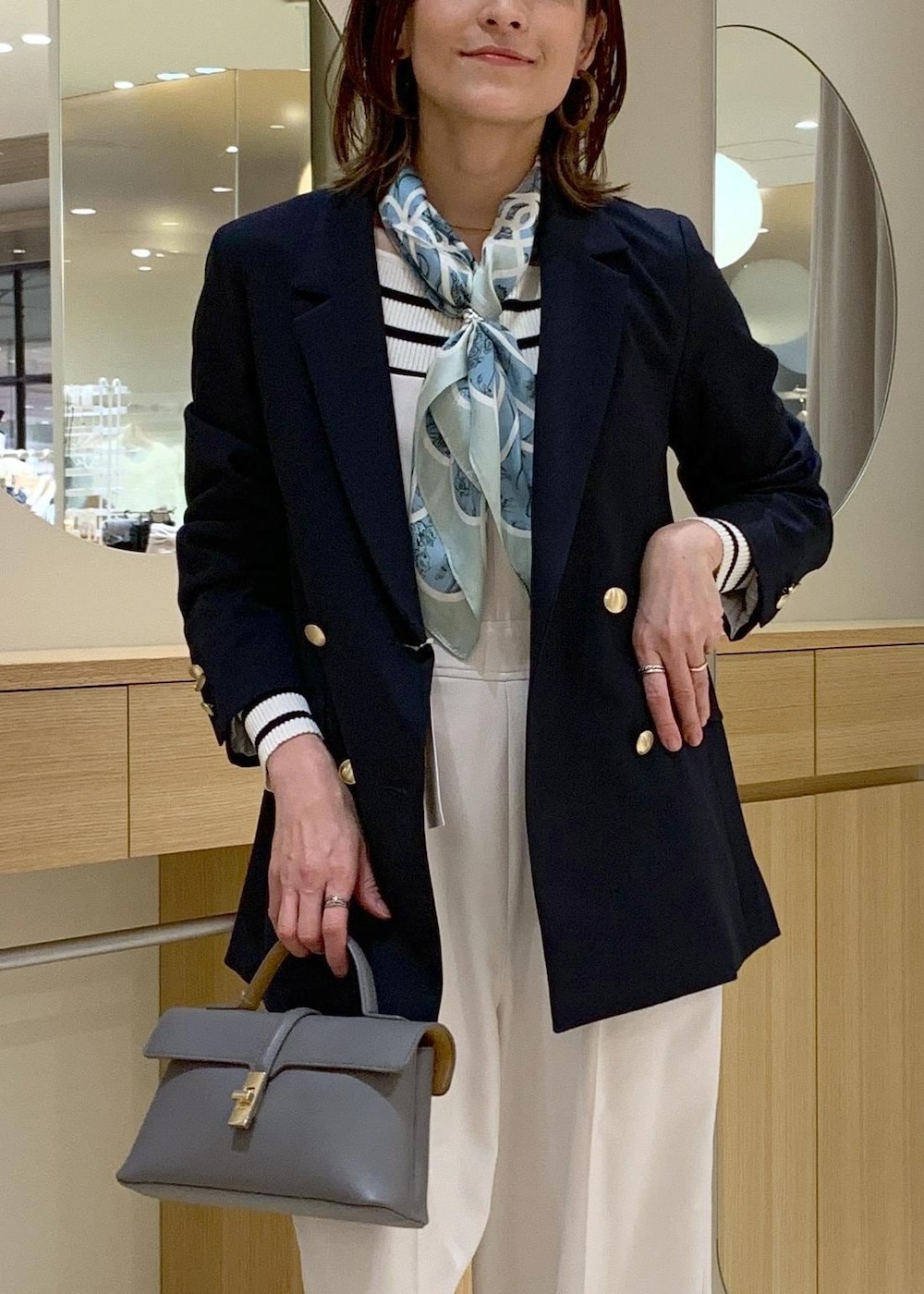 グレー系のショルダーバッグ、ホワイト系のニット/セーター、ブルー系のテーラードジャケットを着用したレディースの冬コーディネートの5枚目の写真