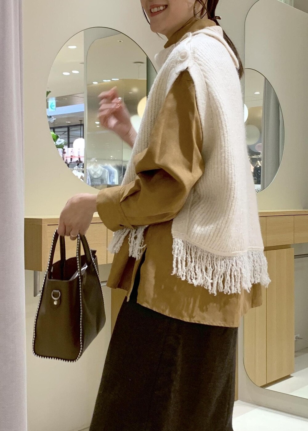 ベージュ系のブーツ、ブラウン系のスカート、イエロー系のシャツ/ブラウスを着用したレディースの秋コーディネートの6枚目の写真