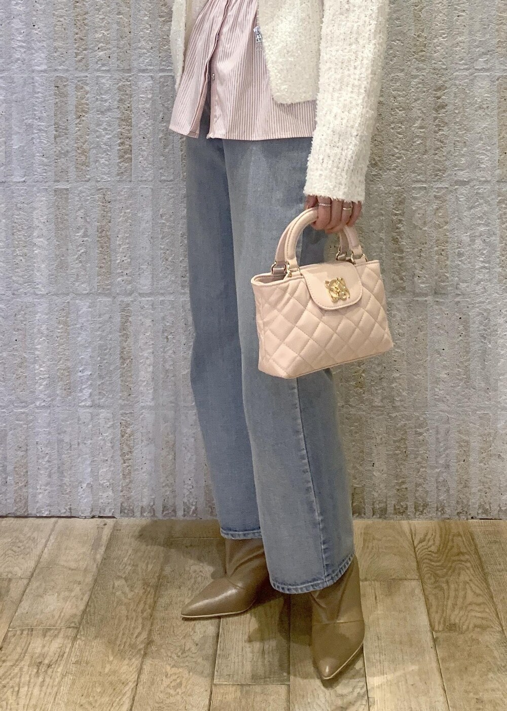 ベージュ系のブーツ、ブルー系のデニムパンツ、ピンク系のシャツ/ブラウスを着用したレディースの冬コーディネートの10枚目の写真