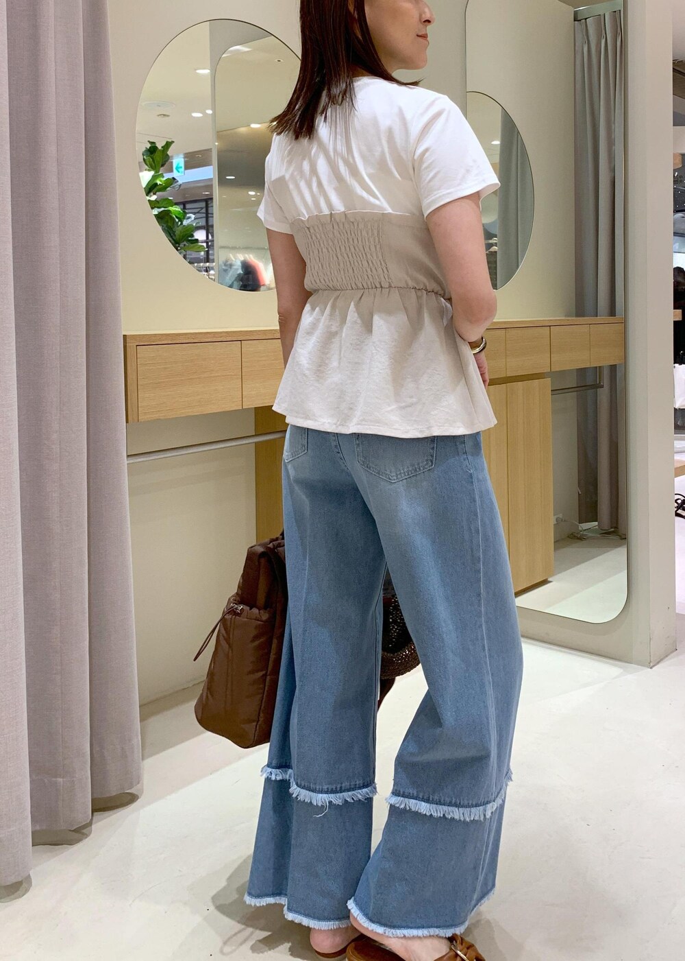 イエロー系のサンダル、ホワイト系のTシャツ/カットソー、ブルー系のデニムパンツを着用したレディースの夏コーディネートの4枚目の写真