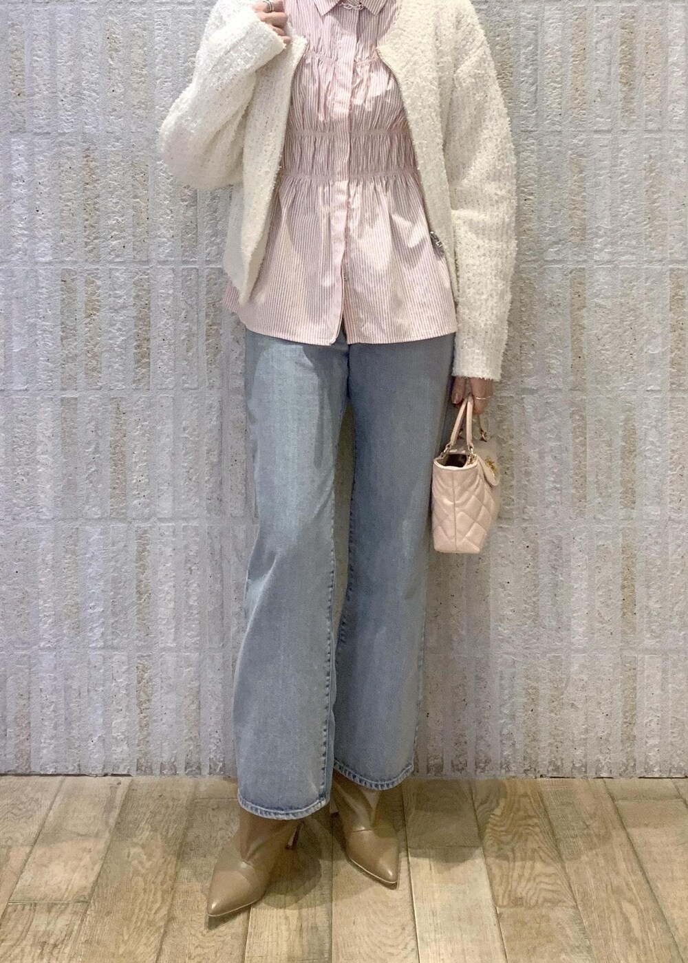 ベージュ系のブーツ、ブルー系のデニムパンツ、ピンク系のシャツ/ブラウスを着用したレディースの冬コーディネートの5枚目の写真