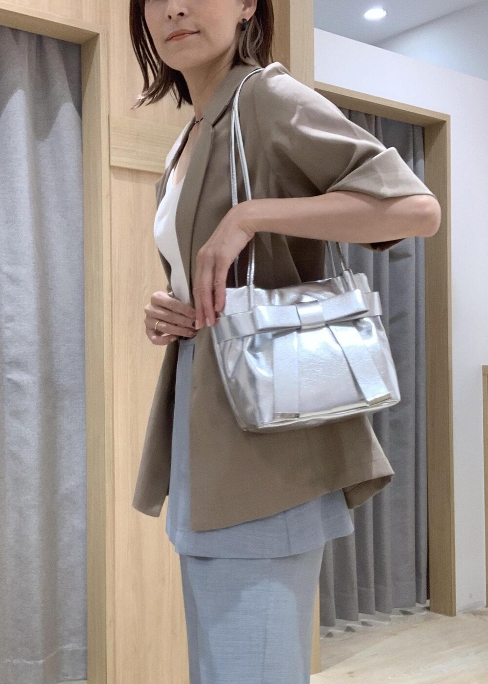 ホワイト系のキャミソール、ホワイト系のサンダル、ブルー系のスラックスを着用したレディースの夏コーディネートの7枚目の写真