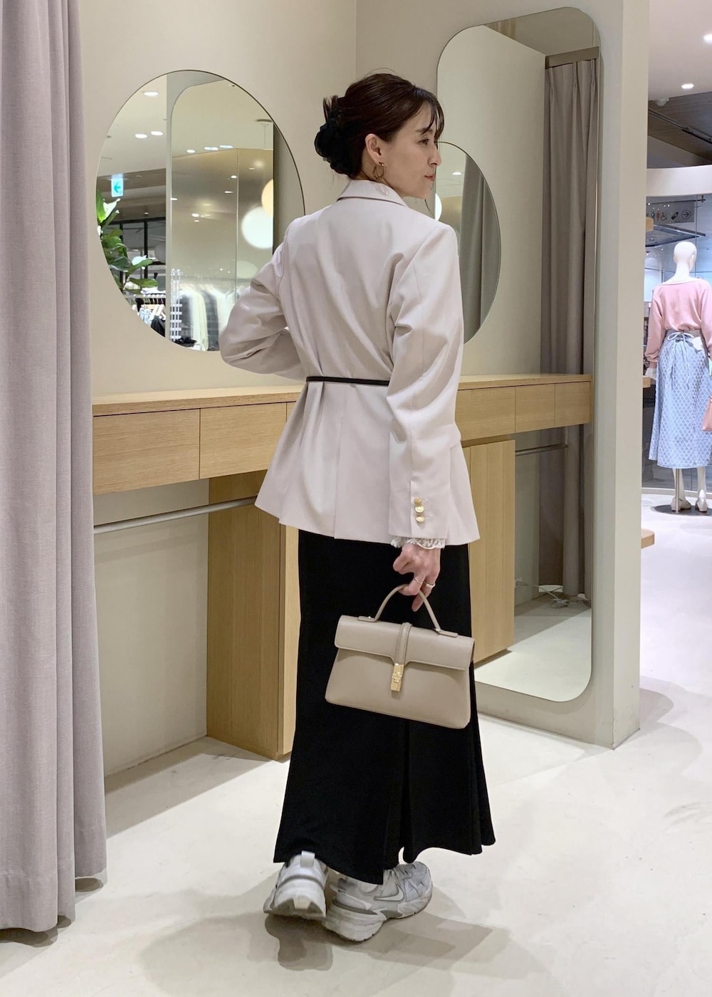 ブラック系のスカート、ホワイト系のTシャツ/カットソー、ベージュ系のテーラードジャケットを着用したレディースの冬コーディネートの5枚目の写真