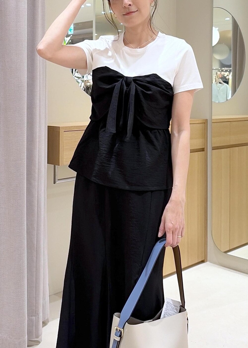 ベージュ系のトートバッグ、ブラック系のパンプス、ブラック系のTシャツ/カットソーを着用したレディースの春コーディネートの8枚目の写真