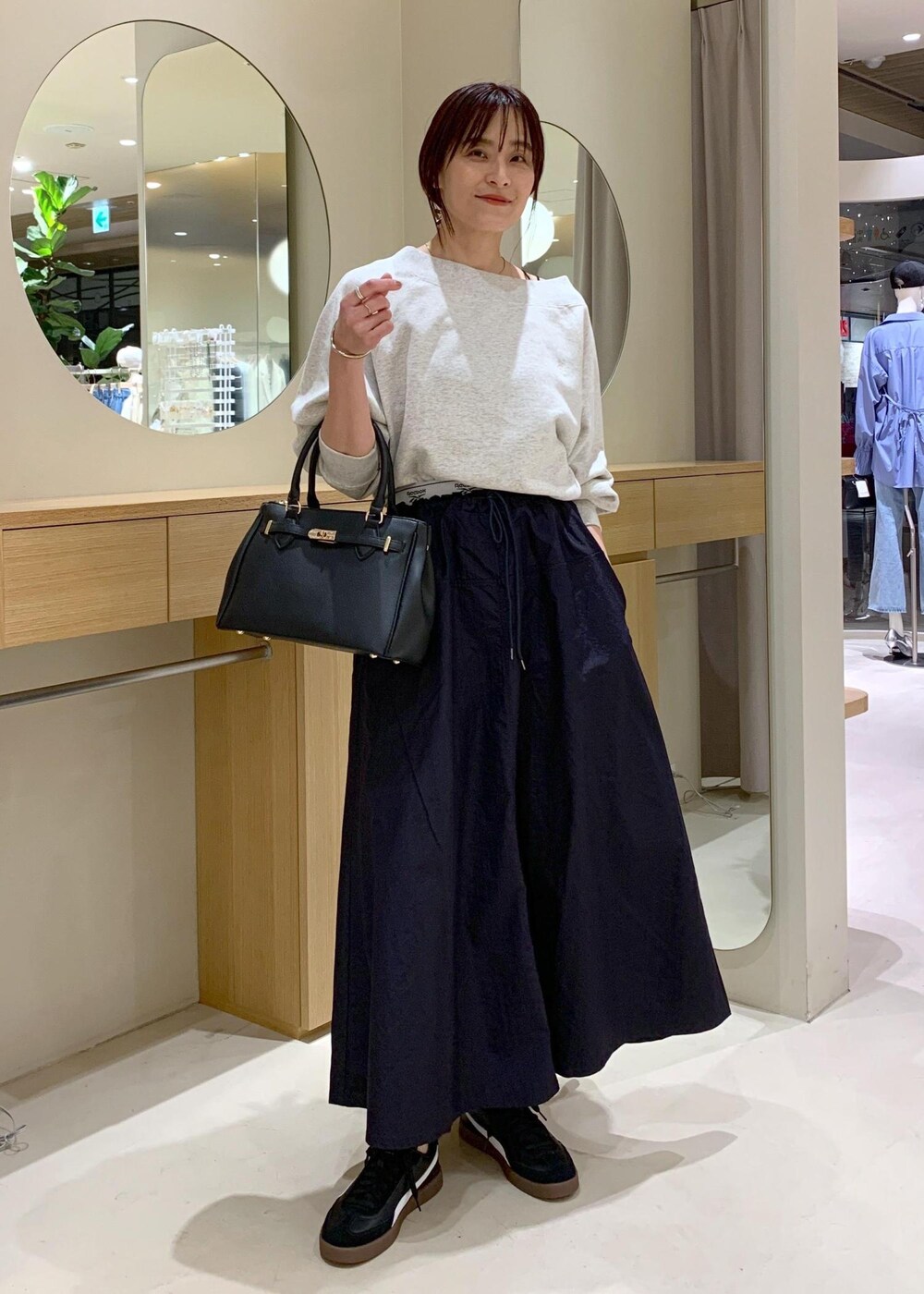 ブラック系のキャミソール、ブルー系のスカート、ホワイト系のスウェットを着用したレディースの春コーディネートの3枚目の写真