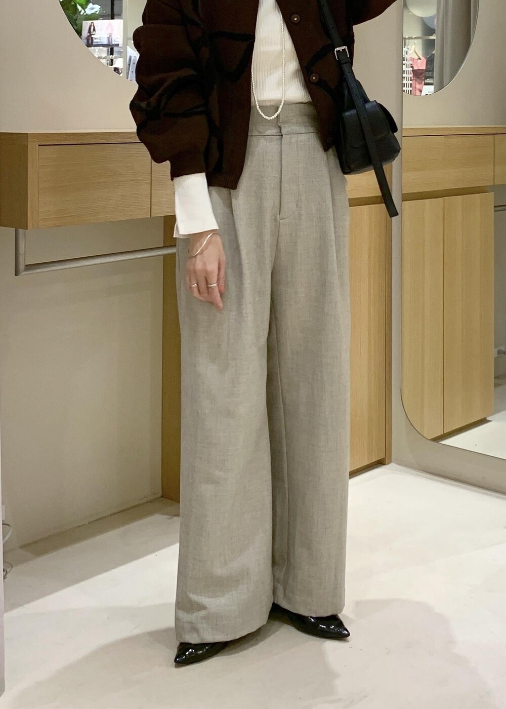 ブラック系のショルダーバッグ、ベージュ系のその他パンツ、ブラウン系のカーディガン/ボレロを着用したレディースの秋コーディネートの9枚目の写真