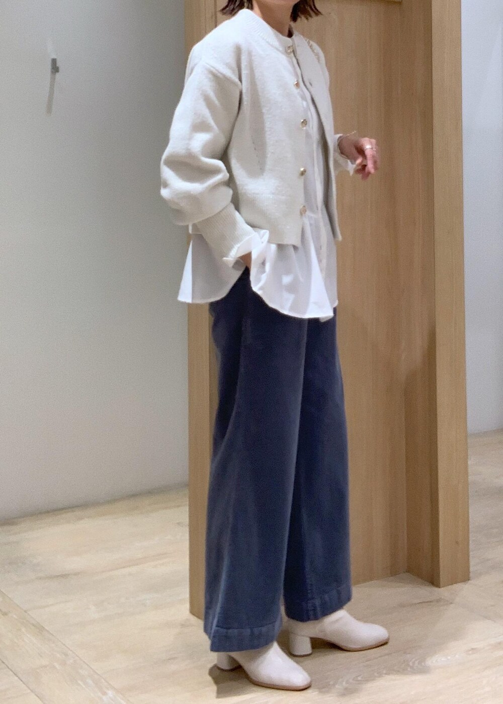 ホワイト系のショルダーバッグ、ホワイト系のカーディガン/ボレロ、ホワイト系のブーツを着用したレディースの秋コーディネートの9枚目の写真