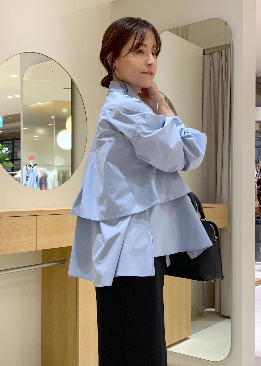 ブラック系のパンプス、ブラック系のスカート、ブルー系のシャツ/ブラウスを着用したレディースの夏コーディネートの8枚目の写真