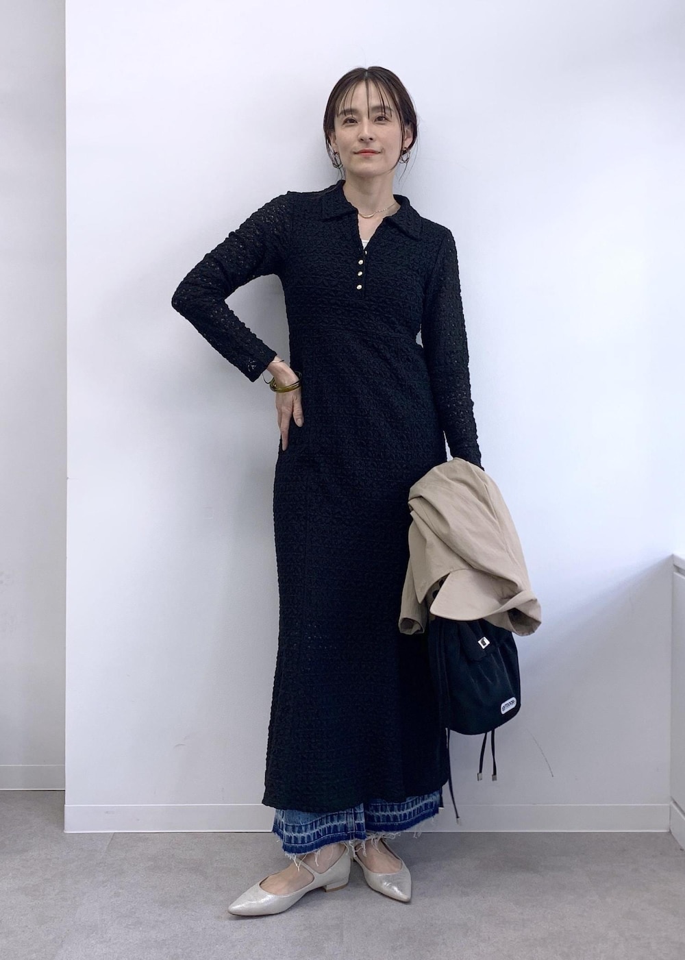 ブラック系のショルダーバッグ、ベージュ系のトレンチコート、ブルー系のデニムパンツを着用したレディースの冬コーディネートの6枚目の写真