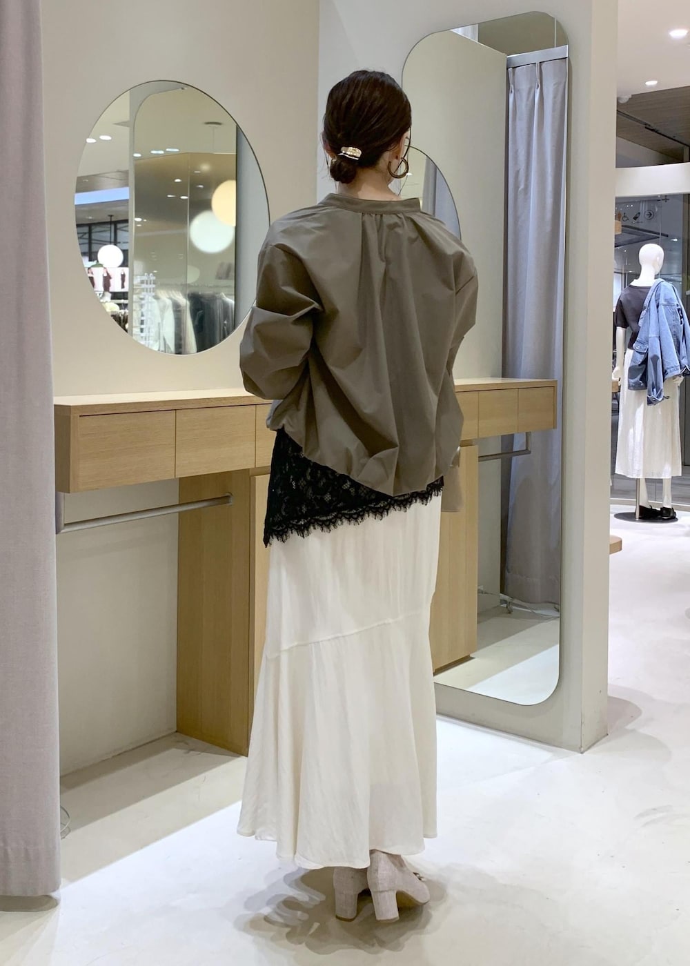 ベージュ系のパンプス、ホワイト系のスカート、ブラック系のキャミソールを着用したレディースの春コーディネートの5枚目の写真