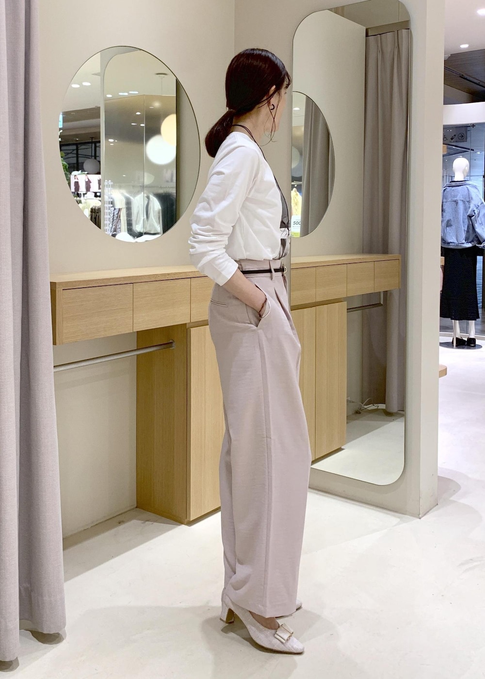 ホワイト系のショルダーバッグ、ベージュ系のパンプス、ホワイト系のナイロンジャケットを着用したレディースの春コーディネートの6枚目の写真