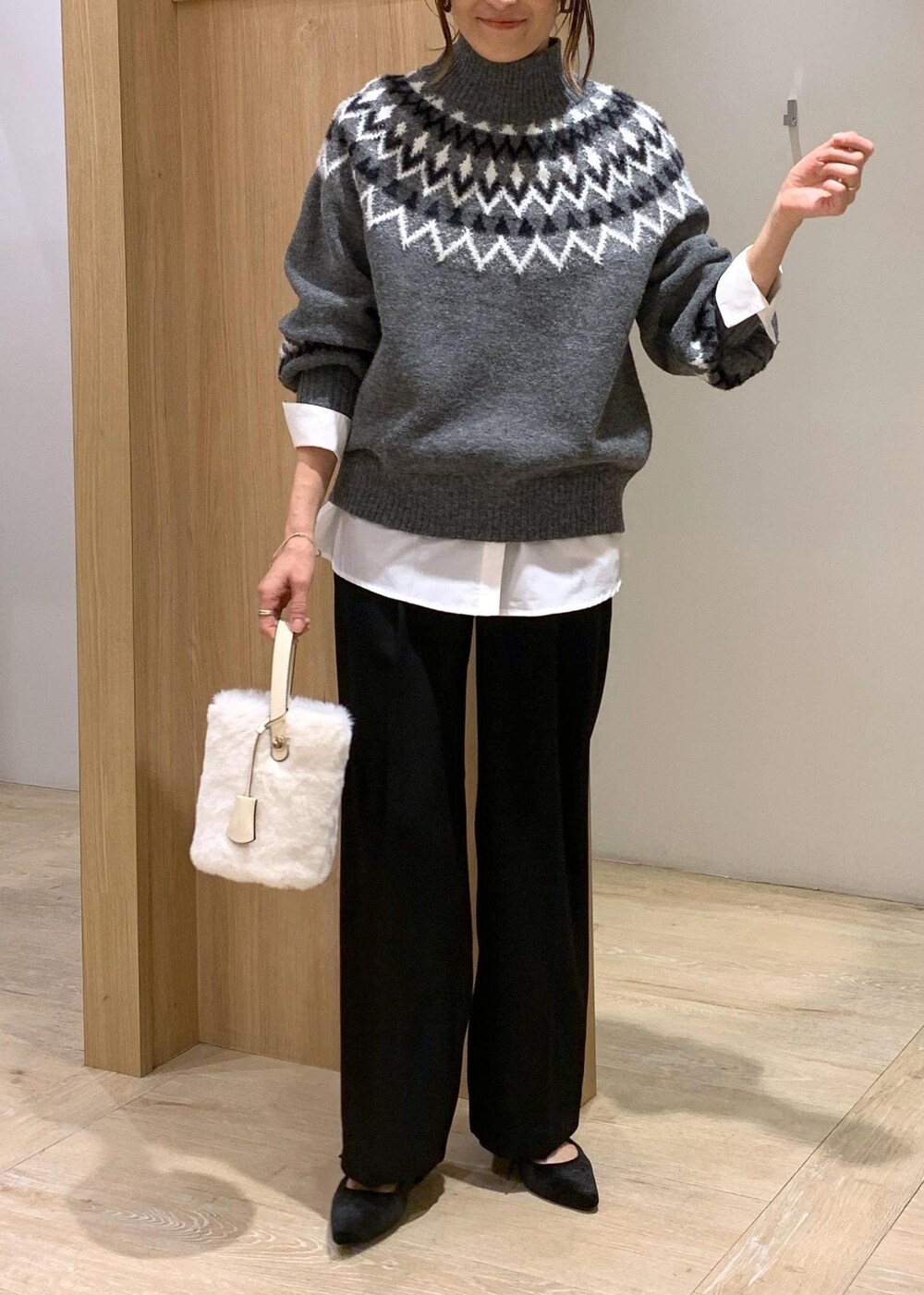 ホワイト系のショルダーバッグ、ブラック系のスラックス、ホワイト系のシャツ/ブラウスを着用したレディースの冬コーディネートの6枚目の写真