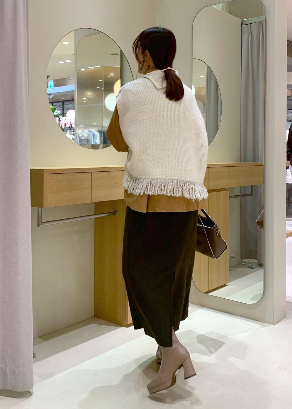 ベージュ系のブーツ、ブラウン系のスカート、イエロー系のシャツ/ブラウスを着用したレディースの秋コーディネートの3枚目の写真