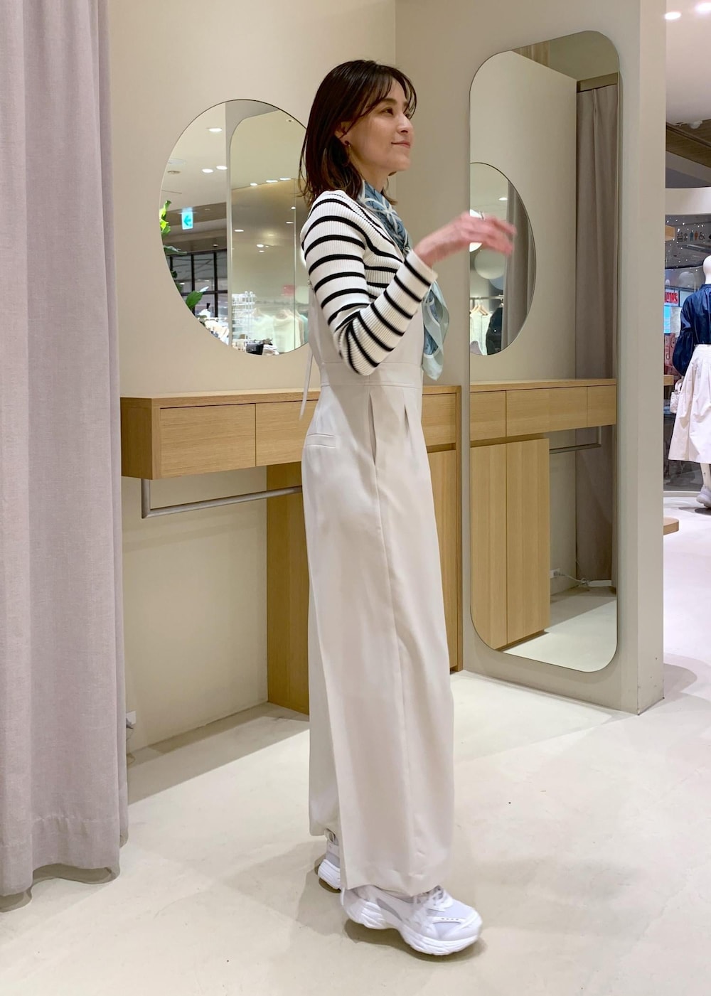 グレー系のショルダーバッグ、ホワイト系のニット/セーター、ブルー系のテーラードジャケットを着用したレディースの冬コーディネートの7枚目の写真