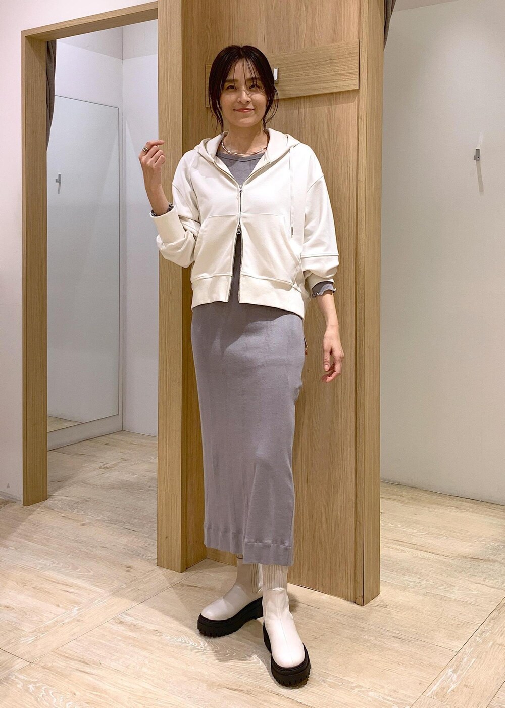 ホワイト系のブーツ、ホワイト系のパーカー、ブラック系のテーラードジャケットを着用したレディースの冬コーディネートの7枚目の写真