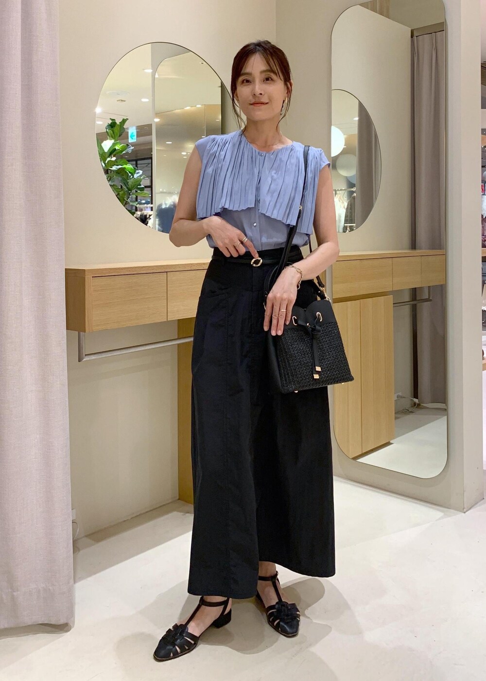 ブラック系のショルダーバッグ、ブルー系のシャツ/ブラウス、ブラック系のスカートを着用したレディースの夏コーディネートの2枚目の写真