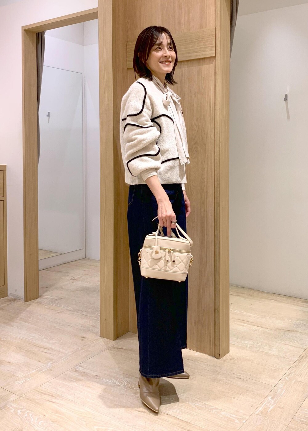 ブルー系のデニムパンツ、ベージュ系のブーツ、ホワイト系のシャツ/ブラウスを着用したレディースの冬コーディネートの6枚目の写真