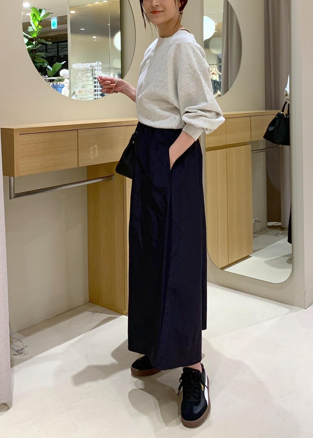 ブラック系のキャミソール、ブルー系のスカート、ホワイト系のスウェットを着用したレディースの春コーディネートの9枚目の写真