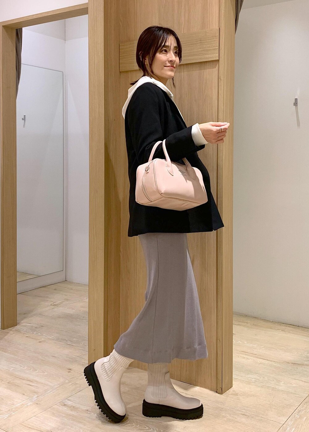 ホワイト系のブーツ、ホワイト系のパーカー、ブラック系のテーラードジャケットを着用したレディースの冬コーディネートの5枚目の写真