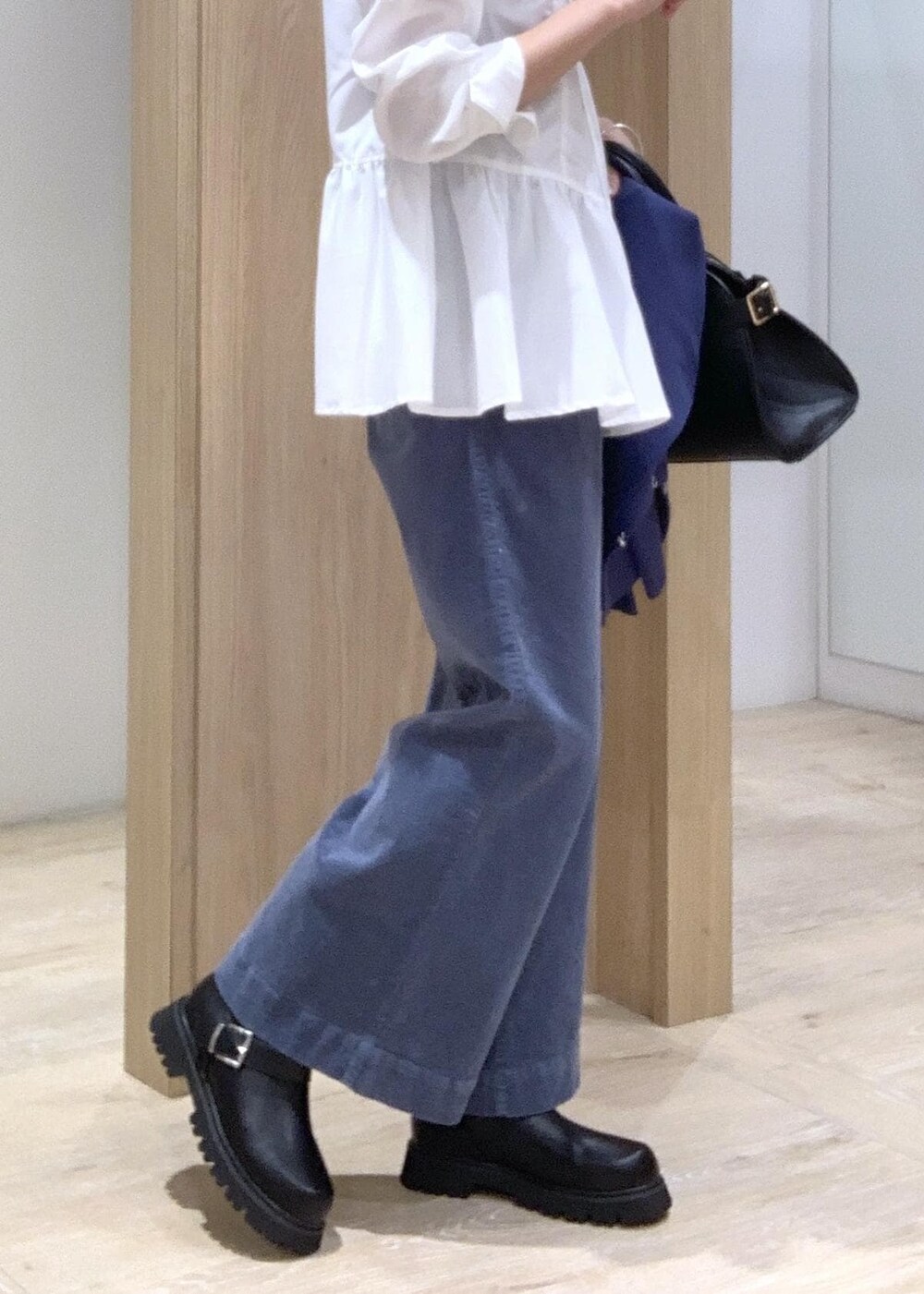 ブラック系のブーツ、ブラック系のトートバッグ、ブルー系のカーディガン/ボレロを着用したレディースの秋コーディネートの9枚目の写真