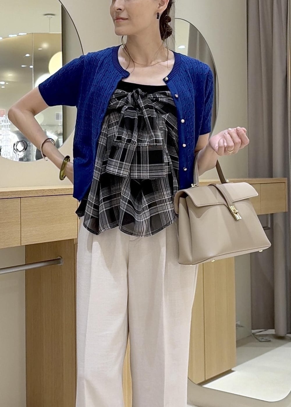 ベージュ系のハンドバッグ、ホワイト系のその他パンツ、ブラック系のシャツ/ブラウスを着用したレディースの夏コーディネートの5枚目の写真