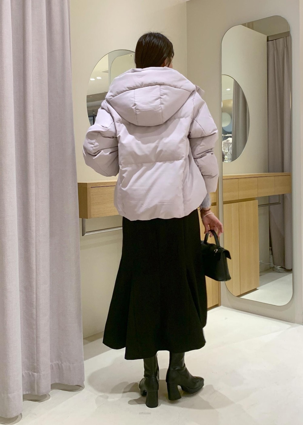 ブラック系のショルダーバッグ、ブラック系のブーツ、ブラック系のスカートを着用したレディースの秋コーディネートの5枚目の写真