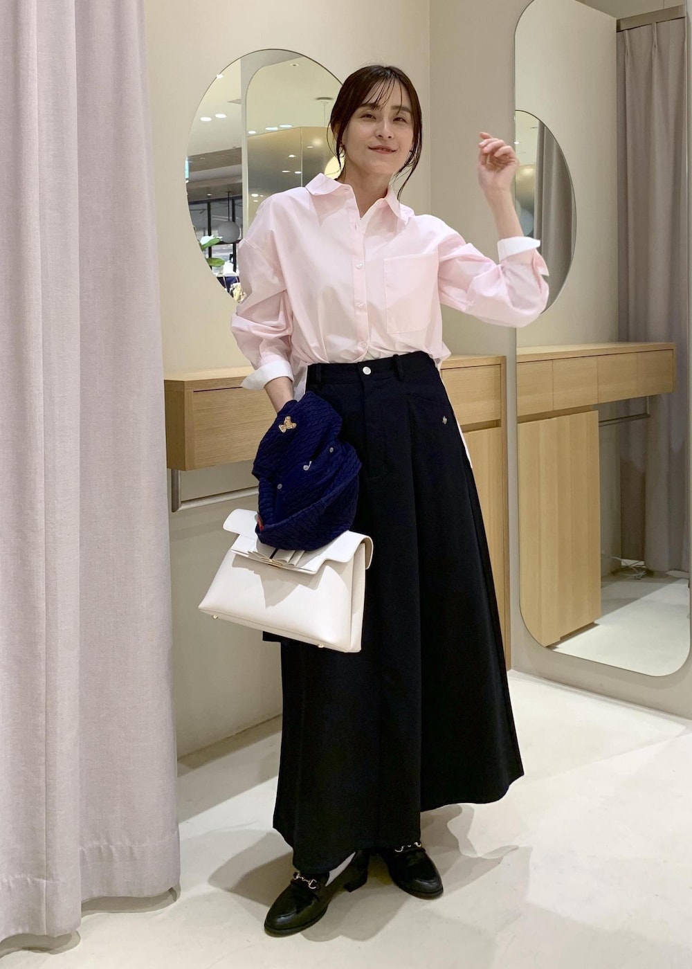 ブラック系のローファー、ホワイト系のハンドバッグ、ピンク系のシャツ/ブラウスを着用したレディースの春コーディネートの2枚目の写真
