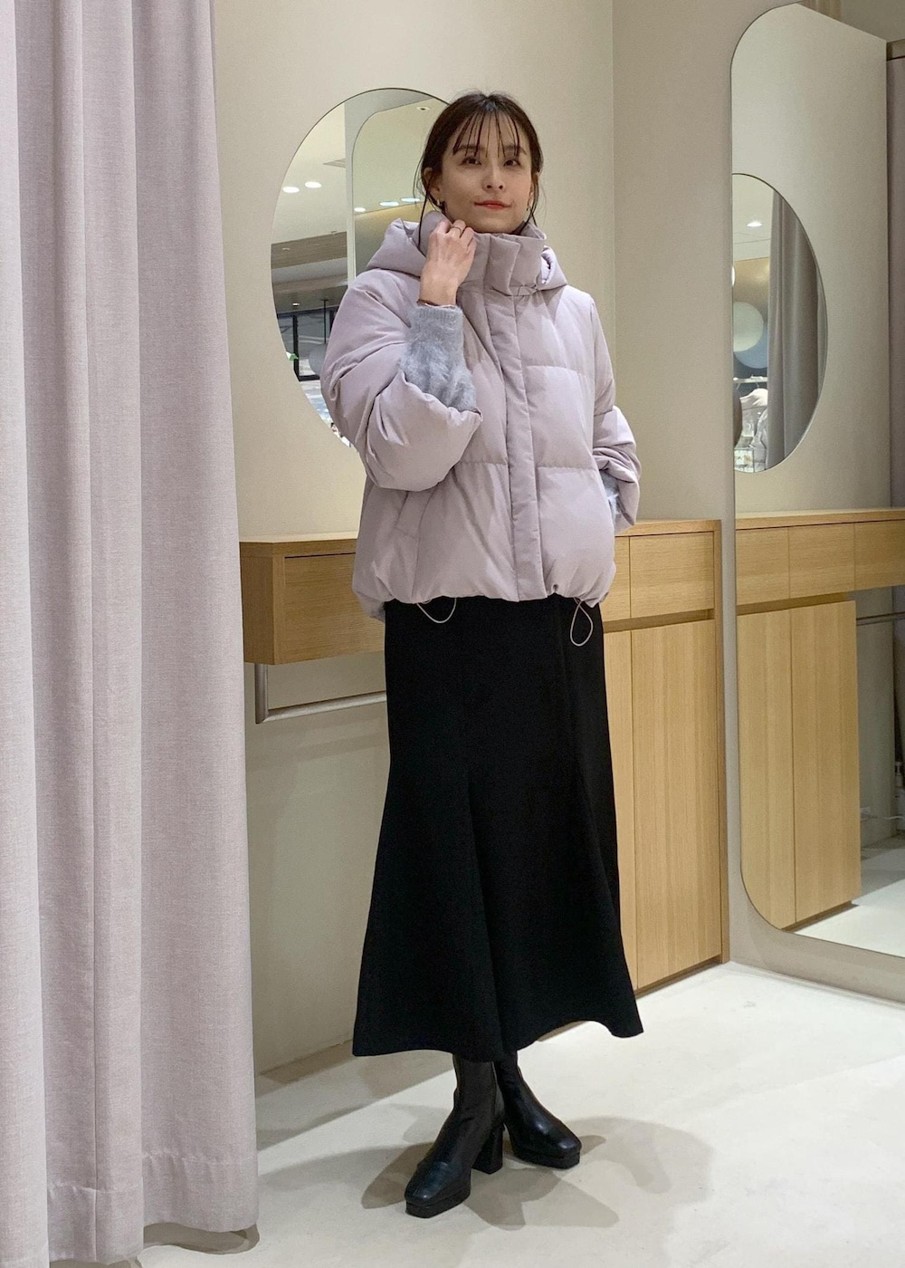 ブラック系のショルダーバッグ、ブラック系のブーツ、ブラック系のスカートを着用したレディースの秋コーディネートの3枚目の写真