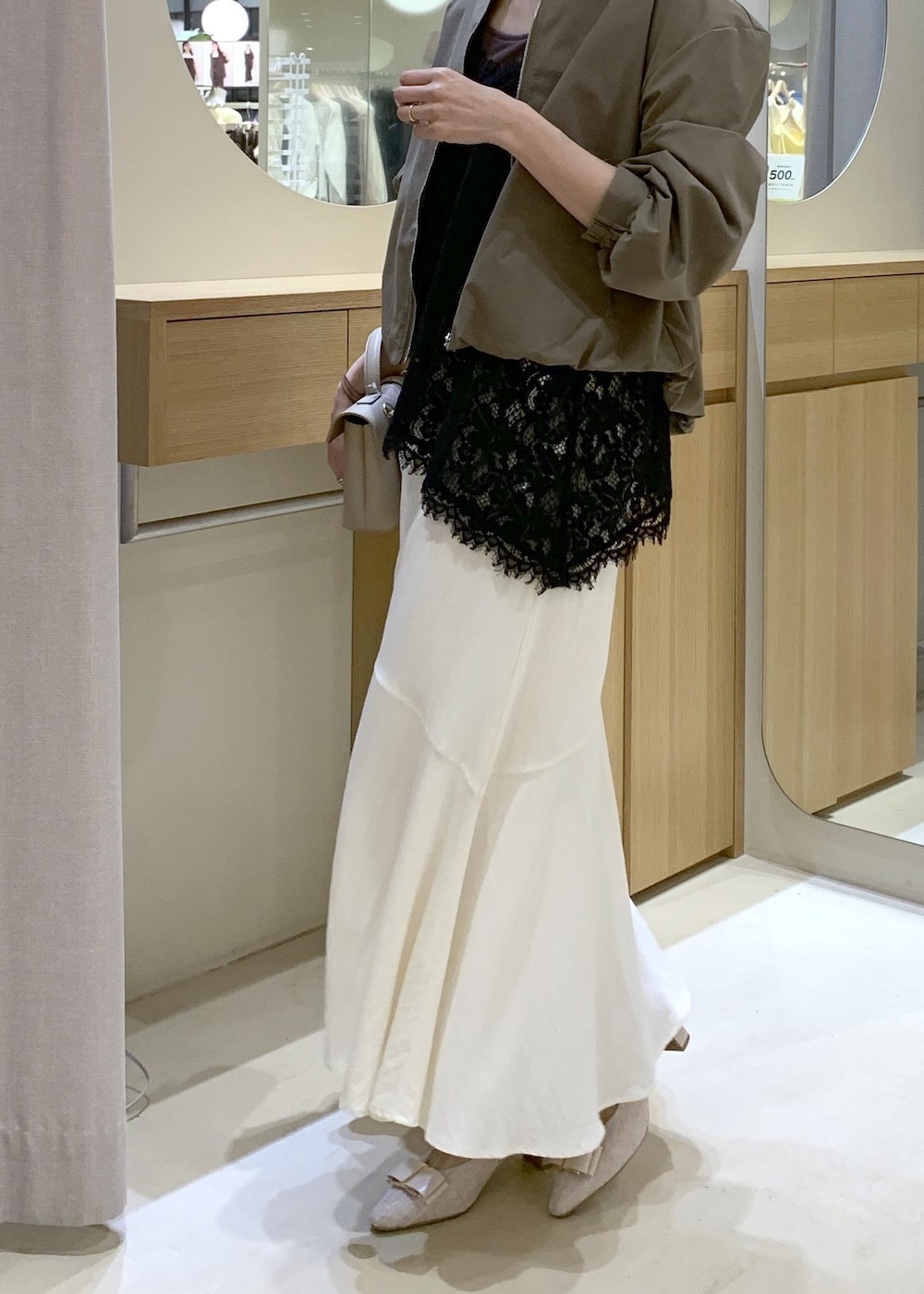 ベージュ系のパンプス、ホワイト系のスカート、ブラック系のキャミソールを着用したレディースの春コーディネートの10枚目の写真