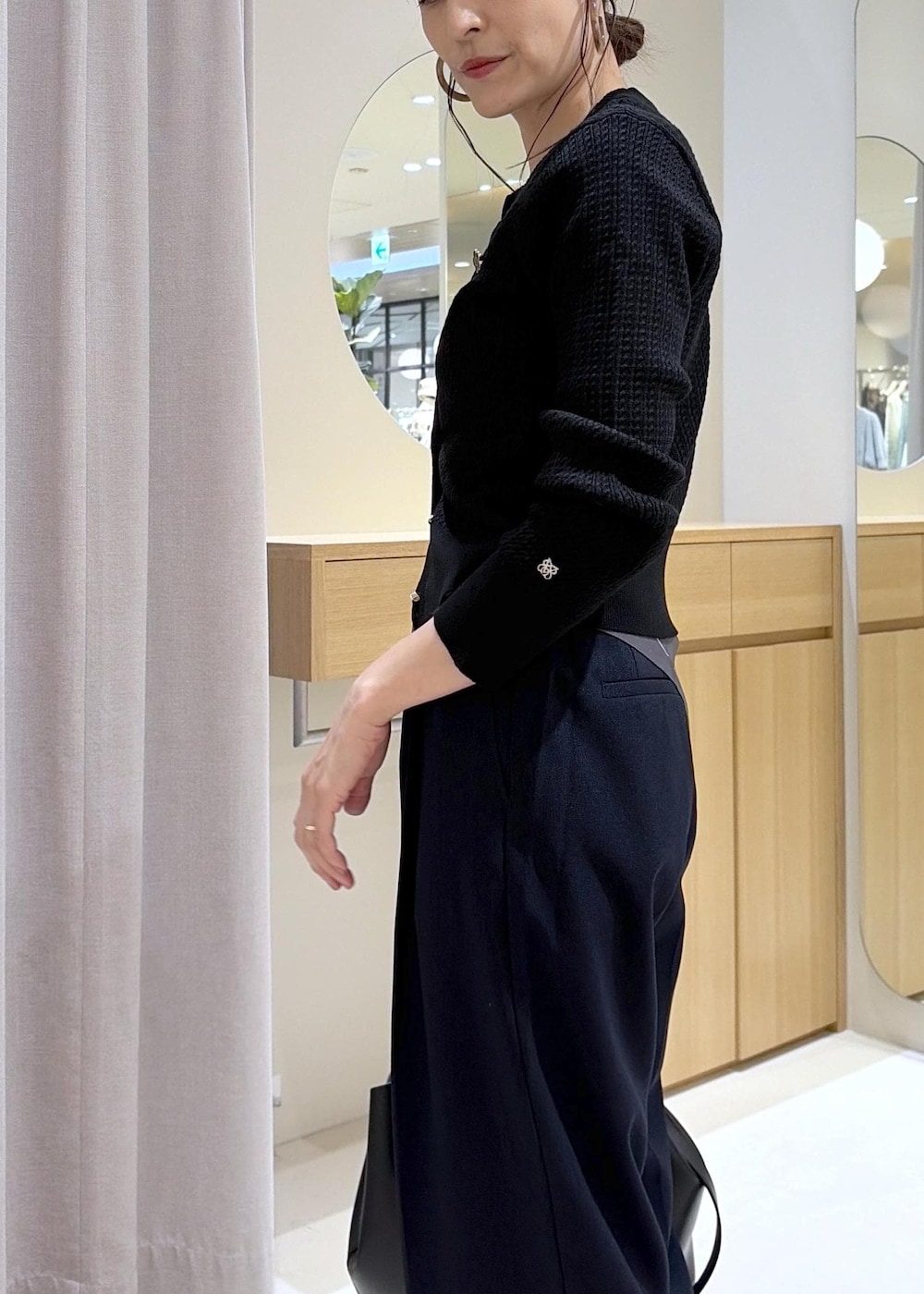 ブラック系のキャミソール、ブルー系のその他パンツ、ブラック系のビジネスバッグを着用したレディースの秋コーディネートの6枚目の写真