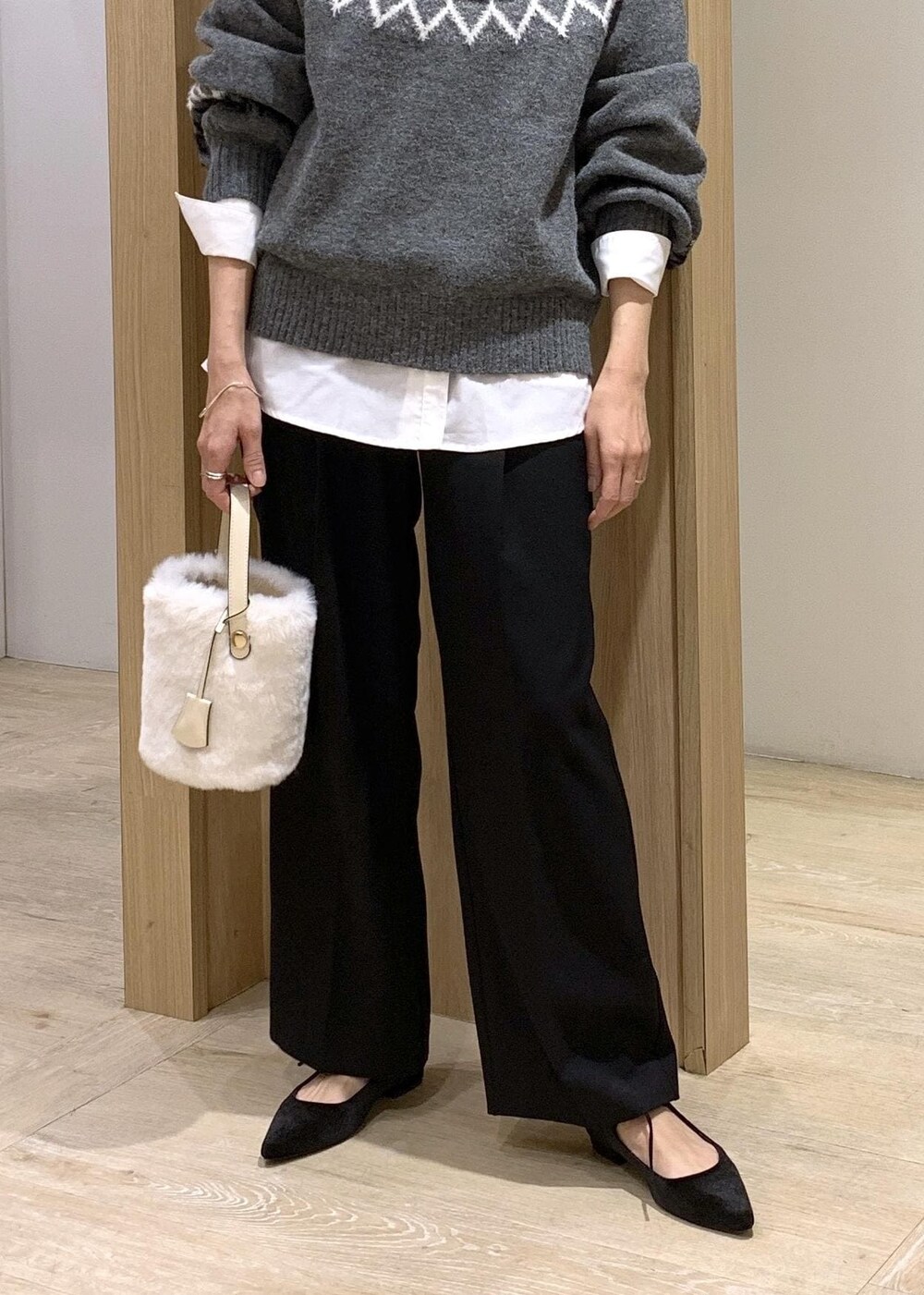 ホワイト系のショルダーバッグ、ブラック系のスラックス、ホワイト系のシャツ/ブラウスを着用したレディースの冬コーディネートの9枚目の写真